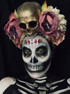 Halloween skull makeup on female model with headdress.