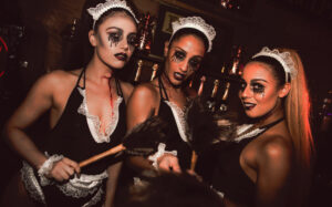 Three barmaids in maid costumes with Halloween makeup.