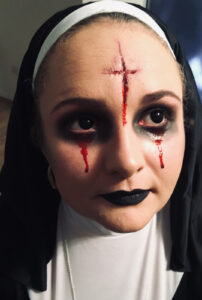 Halloween horror makeup on a woman dressed as a nun.