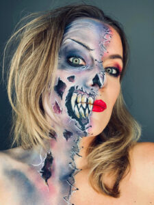 A woman with Halloween makeup showing half zombie face and half beauty face.