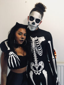 A couple with skull and cat Halloween makeup.