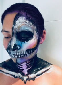 Skull makeup with purple and pink paint.