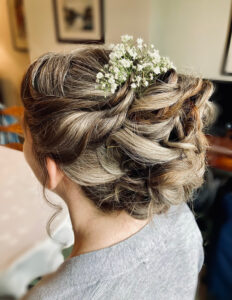 Layered bridal hairstyle with floral accessories.