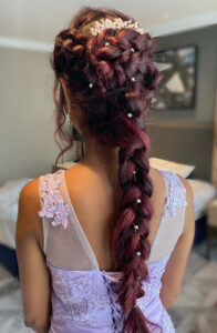 Long bridal plait with red hair and accessories.