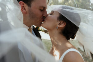 A bride and groom kiss after their wedding.