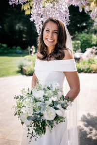 A smiling bride holding flowers.
