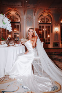 A beautiful bride sitting at a table to eat.