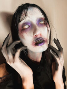 An Asian woman with scary makeup that looks like she is possessed.