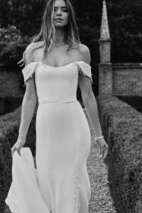 Black and white photo of pretty bride with off-the-shoulder dress.